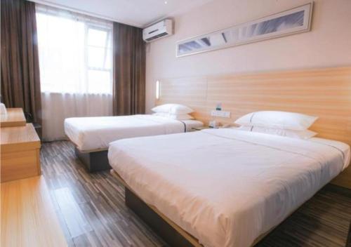 长沙City Comfort Inn Changsha Wuyi Avenue Yingbin Road的酒店客房设有两张床和窗户。