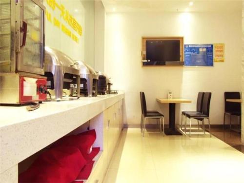黄石City Comfort Inn Huangshi Wanda Plaza Huashan Road的一间设有桌椅的柜台的等候室