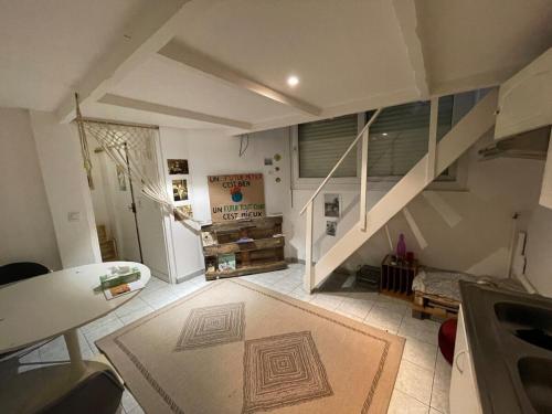 庞坦Maisonnette en duplex 25 M2, Pantin porte de Paris的一间带楼梯和地毯的客厅