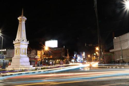 日惹Cahaya Kasih Malioboro Hotel的一条城市街道上晚上的白色大纪念碑