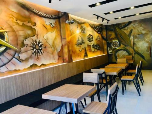 南府Nanloftroom Airport的餐厅设有木桌和壁画
