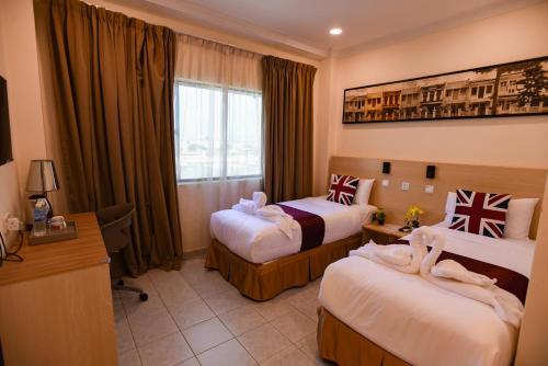 吉隆坡hotel bintang的酒店客房配有两张床和一张书桌