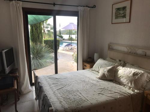 珊瑚湾Villa Manzanillo的一间卧室配有一张床,享有游泳池的景色