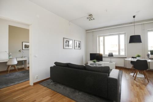 赫尔辛基Kotimaailma Apartments Kamppi - 1BR for 3 persons的带沙发和书桌的客厅