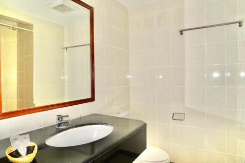雅加达Stay 'd Kuningan的一间带水槽、镜子和卫生间的浴室