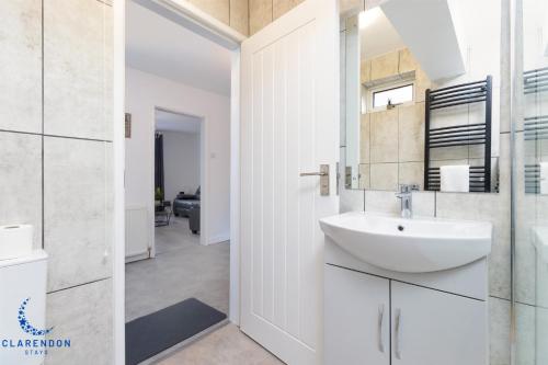 利明顿温泉3BR Home with Driveway Leamington Spa Town Centre的白色的浴室设有水槽和镜子