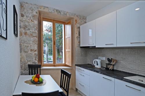 杜布罗夫尼克Ella la Bella II Dubrovnik Old town的厨房配有白色橱柜和水果桌