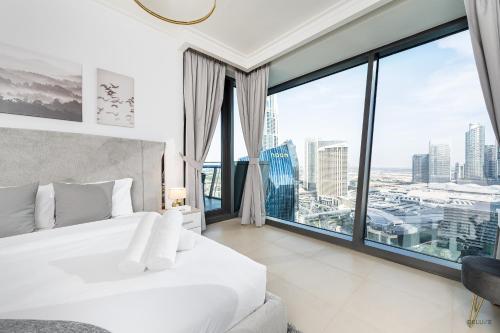 迪拜Gorgeous 2BR Apartment in Burj Vista Tower 1 Downtown Dubai by Deluxe Holiday Homes的卧室设有白色的床和大窗户
