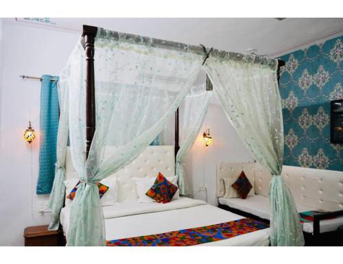 乌代浦Hotel Everest International,Udaipur的一间卧室配有一张带天蓬的床