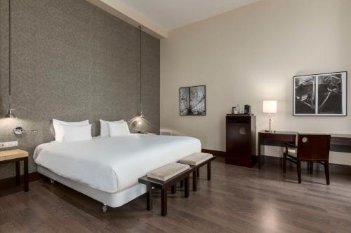 海牙海牙NH酒店的酒店客房设有一张白色大床和一张书桌
