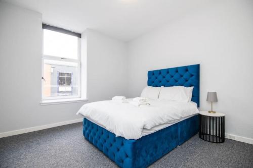 邓迪Bright beautiful flat in Dundee的白色客房的一张蓝色床,设有窗户