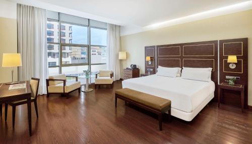 巴达霍斯NH埃斯特雷马杜拉赌场大酒店的酒店客房设有一张大床和一张书桌。