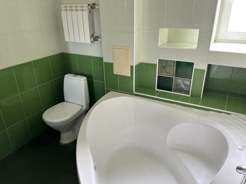 基辅Апартаменти 3-кімнатні, м. Майдан Незалежності的绿色和白色的浴室设有浴缸和卫生间