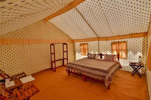 布什格尔Atithi Camp & Resort的卧室配有一张床