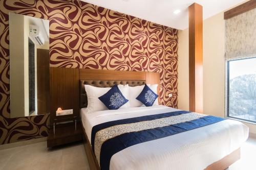 孟买Arton Regency的一间卧室设有一张大床和墙壁