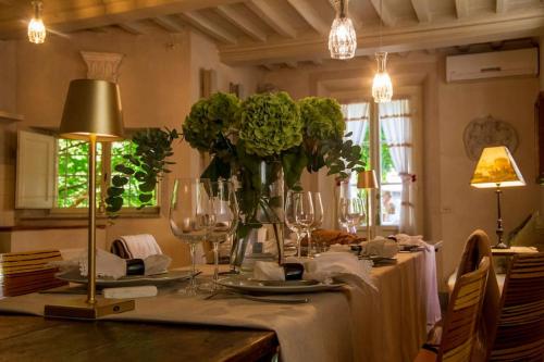 卢卡露坎达圣特阿戈斯蒂诺酒店的桌子上放着眼镜和花瓶
