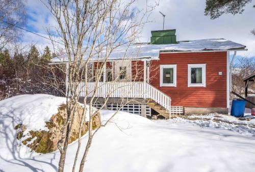 波尔沃Kesäelo的雪上白甲板的红色房子