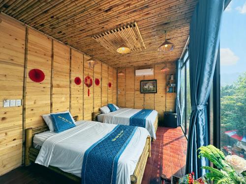 宁平Trang An Moon Garden Homestay的木墙客房的两张床