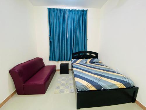 乌姆盖万Serene Nest的一间卧室配有一张床和一张紫色椅子