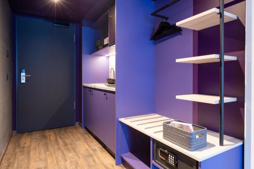 卡尔斯鲁厄the niu Wave的厨房设有紫色的墙壁和蓝色的门