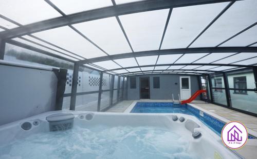 卡迪夫Luxury House, Swimming Pool, Hot Tub, Sauna的屋顶建筑中的热水浴池