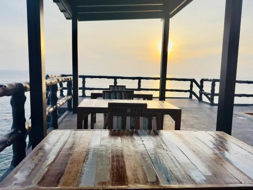涛岛Ocean Front Apartments的一张木桌,坐在码头上,与大海相连