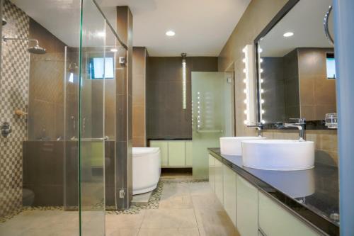 瓜埠Kuah Town - Villa Indah的一间带两个盥洗盆、淋浴和卫生间的浴室