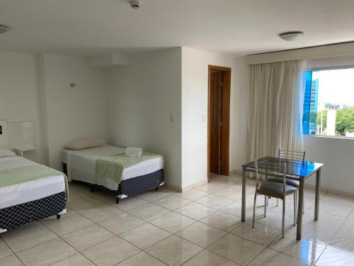 Gama锡罗斯酒店 的酒店客房,设有两张床和一张玻璃桌