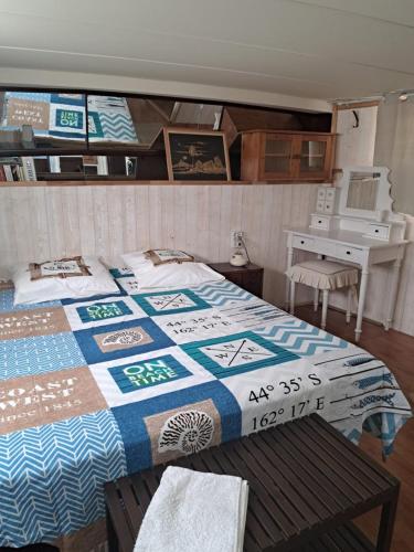 塞特港Yacht, 23 mètres, à quai.的一间卧室配有一张带桌子和一张书桌的床。