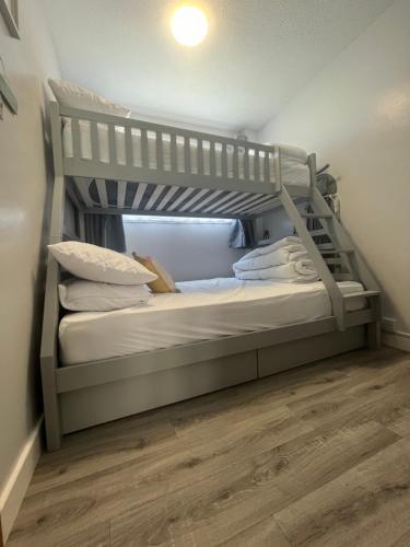 大雅茅斯246, Belle Aire, Hemsby - Beautifully presented two bed chalet, sleeps 5, pet friendly, close to beach!的一间卧室设有两张双层床,铺有木地板。