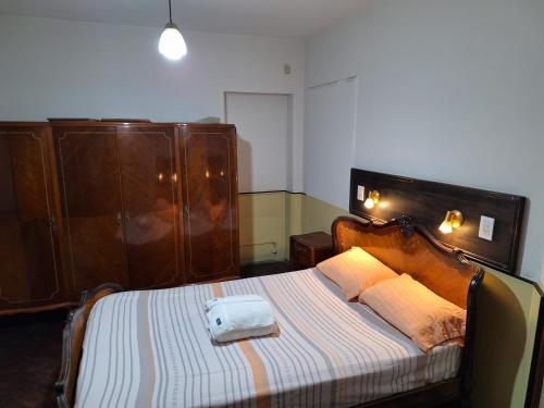 门多萨La posada del Colibrí的一间卧室配有一张大床和木制床头板