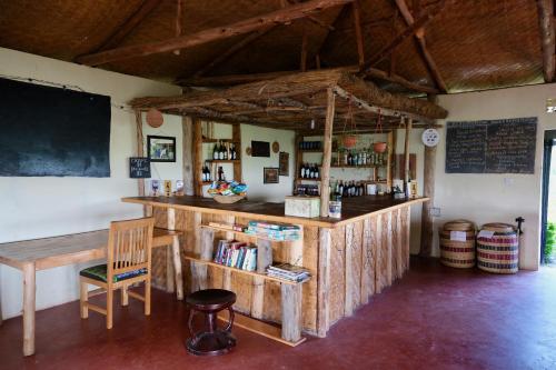 SangaHyena Hill Lodge的一间酒吧,里面摆放着椅子和黑板