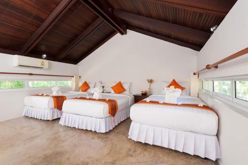 涛岛Ban's Diving Resort SHA Extra Plus的配有白色墙壁和窗户的客房内的三张床
