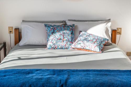 米兰Luxury Loft的一张带蓝色和白色床单及枕头的床