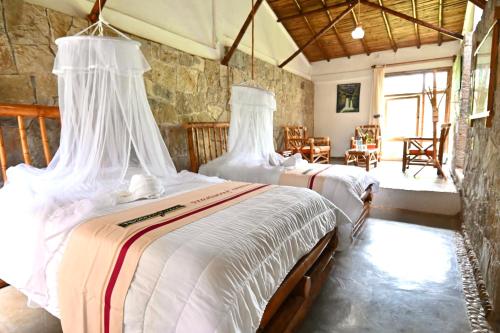 库埃察兰德尔普罗格雷索Cabañas Tosepan Kali的一间卧室配有两张带白色床单的床