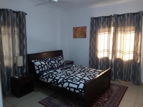 阿克拉RESIDENCE IVOIRE的一间卧室配有床和带窗帘的窗户