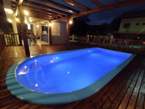 邦比尼亚斯Pousada Bombinhas House的夜间甲板上的蓝色热水浴池