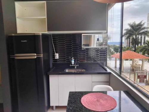 巴西利亚Apart hotel otima localizaçao em Brasilia的厨房配有黑色冰箱和桌子