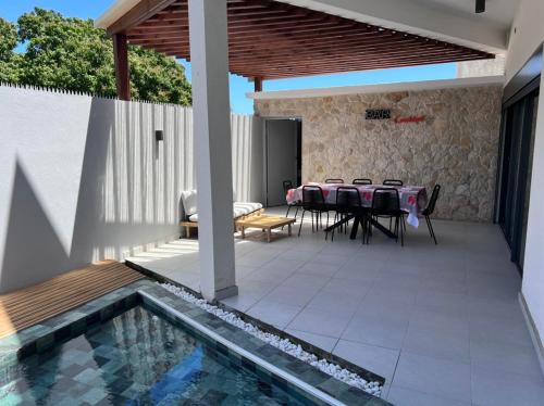 Kani KeliMSLodge的一个带桌椅的庭院和一个游泳池
