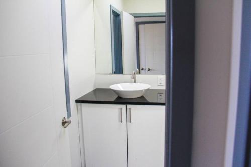 惠灵顿SkyTime Vacations的浴室设有白色水槽和镜子