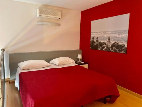 比恩帝纳休闲空间酒店的红色卧室配有一张带红色毯子的床