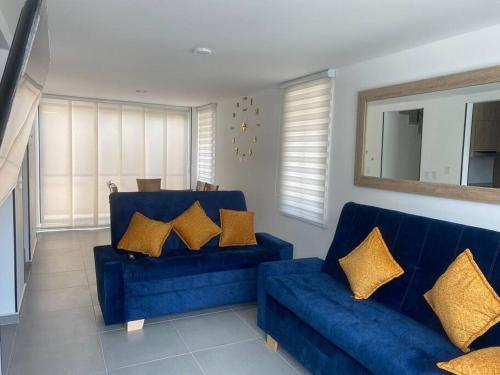拉特瓦伊达Casa Familiar Excelente ubicación con Piscina的客厅里配有带金色枕头的蓝色沙发
