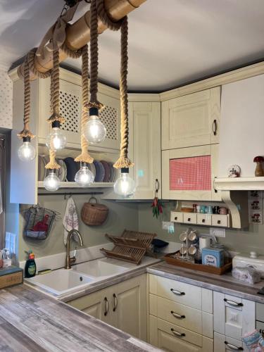 卡尔派尼西翁1957 To Rodo kai to Roido的厨房配有白色橱柜、水槽和灯