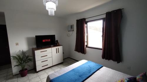 约恩维利Mandallah Hostel的一间卧室设有一张床、一台电视和一个窗口。