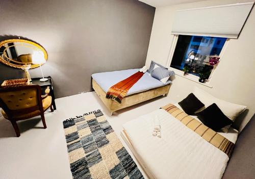 奥勒松Luxury Service Apartment by Chanya的一间卧室设有两张床、一把椅子和一个窗户。