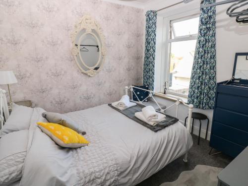 拉内利5 Pontardulais Road的一间卧室配有一张带镜子的床和窗户