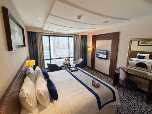 麦加Al Safwah Hotel First Tower的酒店客房设有一张大床和一张书桌。