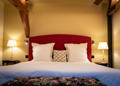 圣奥梅尔CLOS DU BAILLI的一间卧室配有一张大床和红色床头板