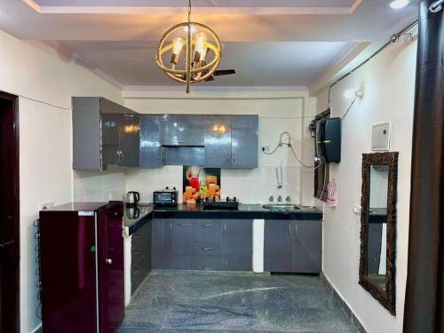新德里Modern 2bhk near Delhi Airports by Nirvana villa Apartments的厨房配有不锈钢橱柜和吊灯。