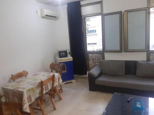 突尼斯Appartement meublé centre ville de Tunis的客厅配有沙发和桌子